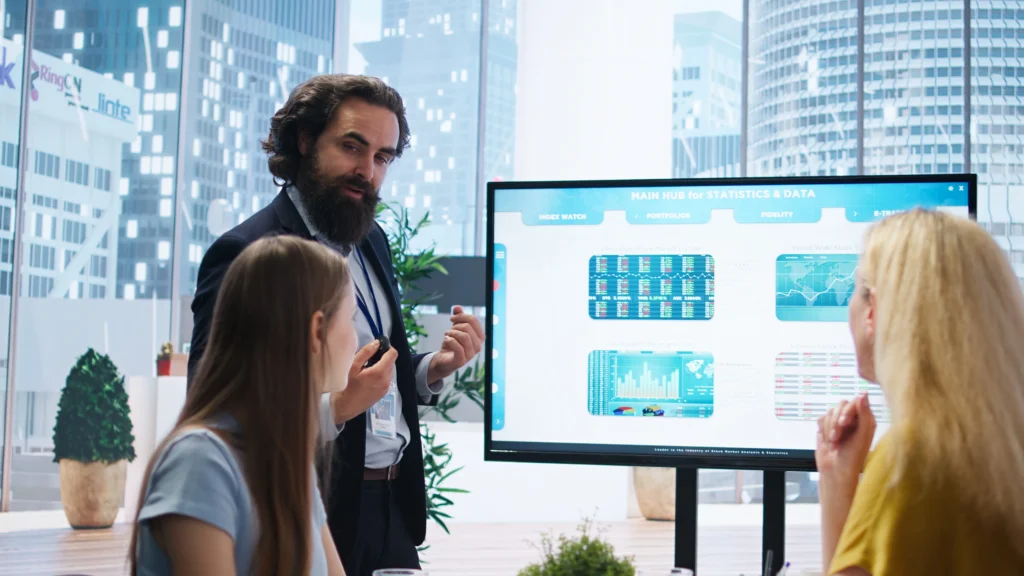 Equipo empresarial observando una pantalla con gráficos de análisis digital en una oficina