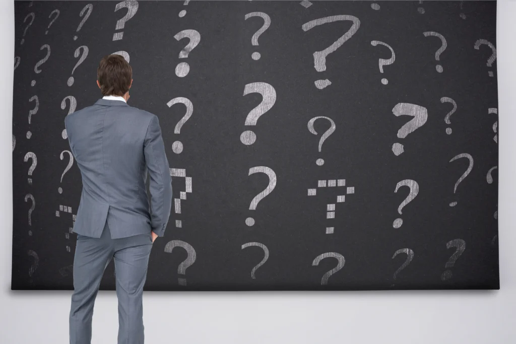 Persona frente a una pizarra con signos de pregunta, representando las decisiones estratégicas que las empresas deben evaluar antes de adoptar IA local.